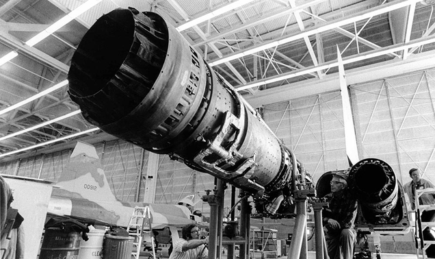 A General Electric J85 being placed in a Northrop F-5 Tiger II, a descendant of the T-38